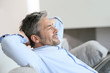 © goodluz - Middle-aged man having a restful moment relaxing in sofa