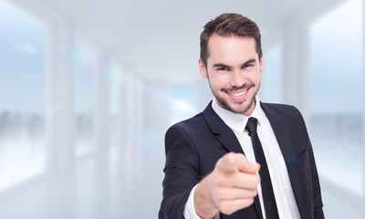 Poster - Composite image of happy businessman pointing at camera