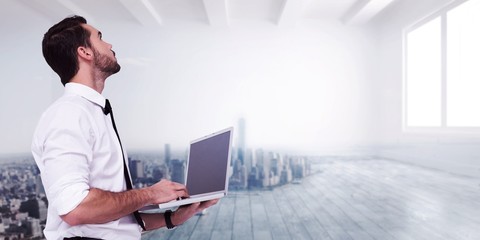 Poster - Businessman standing using a laptop