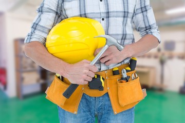 Poster - Composite image of technician holding hammer and hard hat