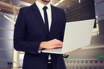 Poster - Composite image of mid section of a businessman using laptop