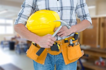 Poster - Composite image of technician holding hammer and hard hat