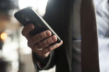 Businessman in suit, jacket,shirt, tie, using his smart phone