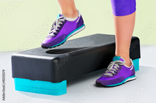 Fotografie, Obraz Female feet in violet sneakers on fitness step.