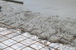 Wet concrete cement flowing over rebar metal