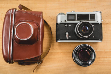 Wall Mural - retro photography set of camera, case and lens on wooden backgro