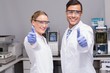 © WavebreakMediaMicro - Smiling scientists looking at camera thumbs up