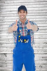 Poster - Composite image of confident plumber showing thumbs up sign