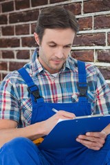Poster - Composite image of plumber writing notes on clipboard