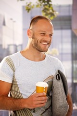 Poster - Happy man walking on street holding coffee