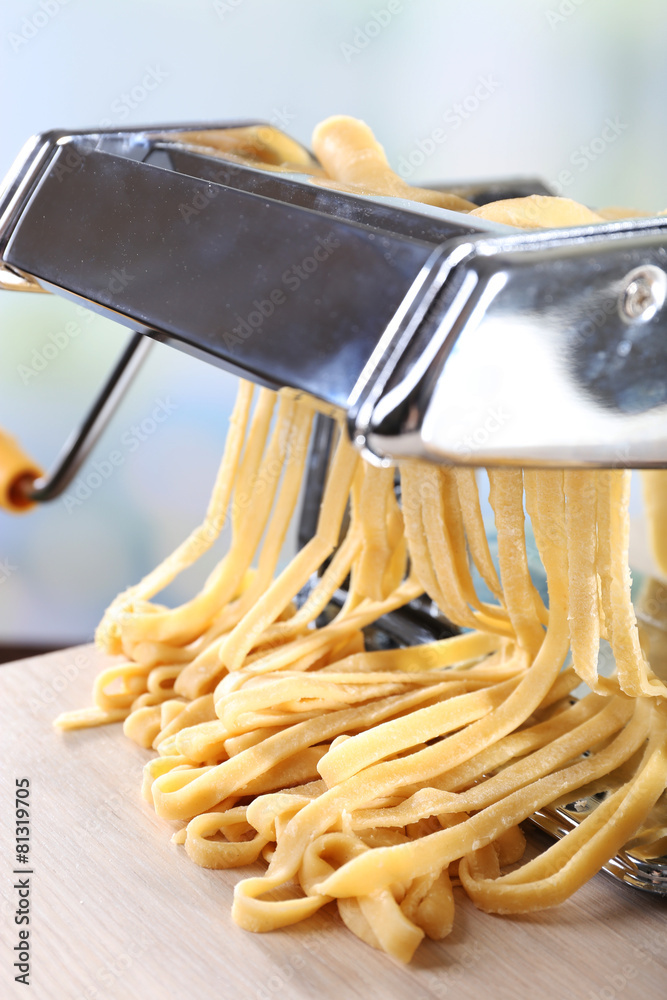 Making noodles with pasta machine on light background