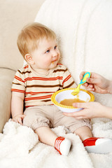 Wall Mural - Mother feeding her happy little cute son