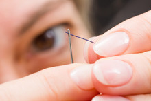 Woman Fingers Threading A Needle