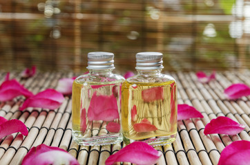 closeup of two essential oil and rose petal