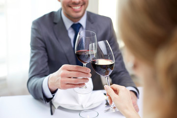 Wall Mural - happy couple with glasses of wine at restaurant