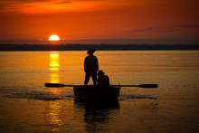 Two Fishermen In A Boat During Sunset