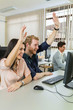 © NDABCREATIVITY - Beautiful young woman and a man raising hands in classroom
