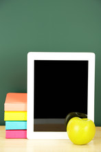 Tablet On Table, On Green Blackboard Background