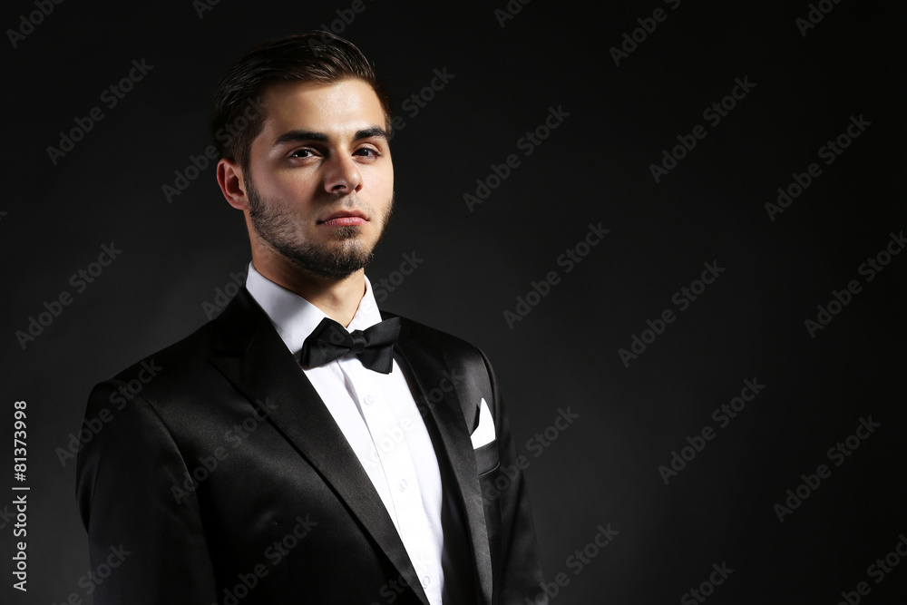 Elegant man in suit on dark background