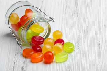 Canvas Print - Colorful candies in jar on wooden background