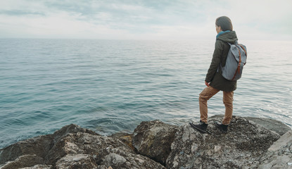 Wall Mural - Woman standing on stone on coast