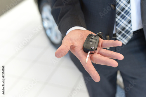 Fotografie, Obraz Verkäufer hält neuen Autoschlüssel in der Hand