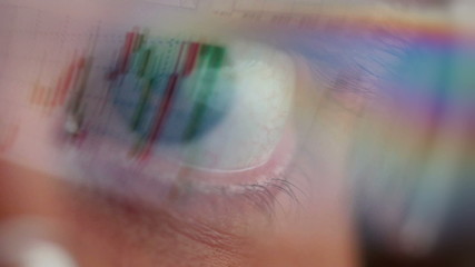 Closeup of glasses wearing men looking into a monitor.