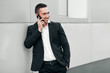 © nikolas_jkd - Smiling happy man talking on mobile phone in a black suit