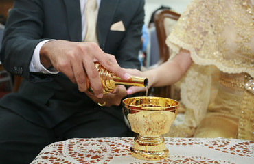 Bride and groom's hands pouring ceremonial water