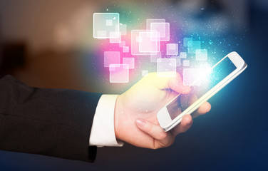Poster - Hand holding smart phone with abstract glowing squares