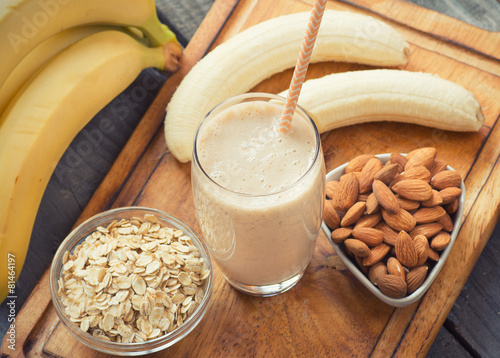 Cuadros en Lienzo Fresh made Banana smoothie on wooden background