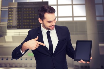 Poster - Composite image of happy businessman pointing with his tablet