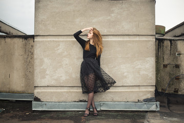 beautiful young girl in a black dress on a windy day