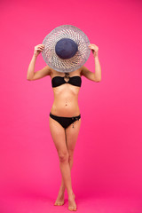 Poster - Woman in bikini covering her face with hat