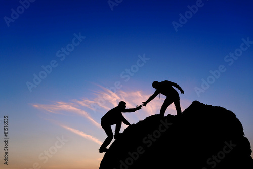 Fotografie, Obraz Silhouette of helping hand between two climber