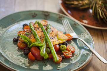 organic Arctic char fish on a bed of roasted tomatoes topped wit