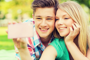 Wall Mural - smiling couple making selfie in park