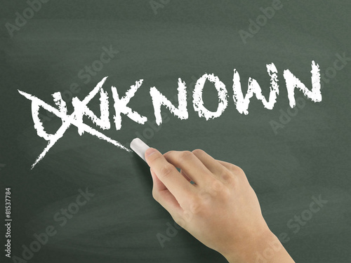 Fotografía hand changing the word unknown into known