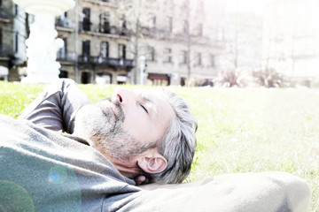 Canvas Print - Mature man having a nap in city park