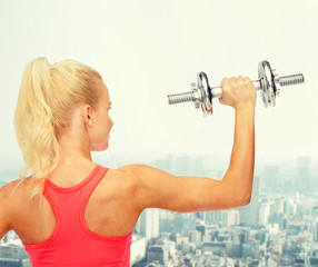 Poster - sporty woman with heavy steel dumbbell from back