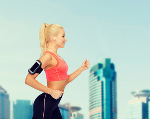 Canvas Print - sporty woman running with smartphone and earphones