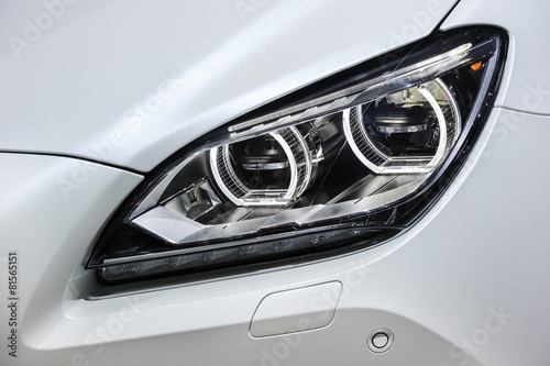 Fényképezés  Headlight with led lamps and hood of white sport modern car