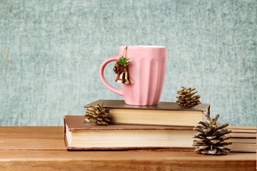 Sticker - Book. Christmas tea mug on books on wooden table over grunge