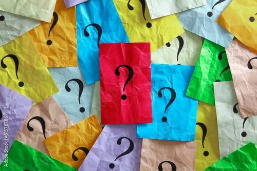 Foto  Viele Fragezeichen - in der Mitte eines auf rotem Zettel