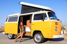 Model Sitting In A Yellow Camper With A Folding Roof
