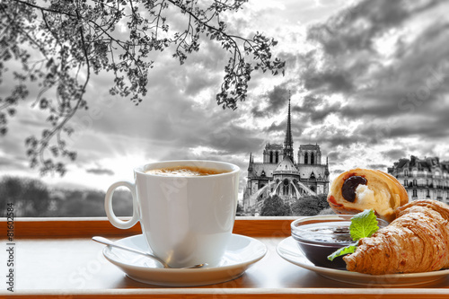 Fototapeta na wymiar Notre Dame cathedral with coffee and croissants in Paris, France