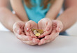 © Syda Productions - close up of family hands holding euro money coins