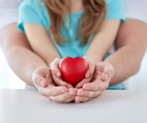 Wall Mural - close up of man and girl holding red heart shape