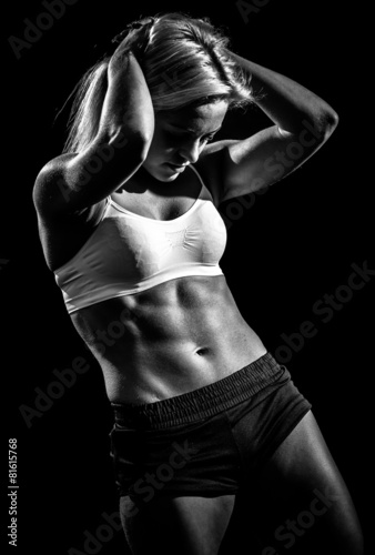 Naklejka - mata magnetyczna na lodówkę muscular female against black background.