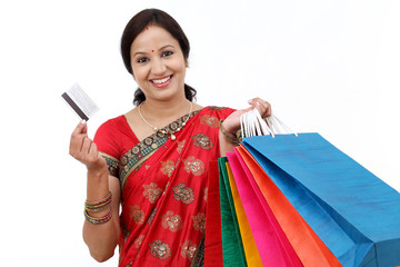 Young smiling traditional woman with shopping bags and credit ca